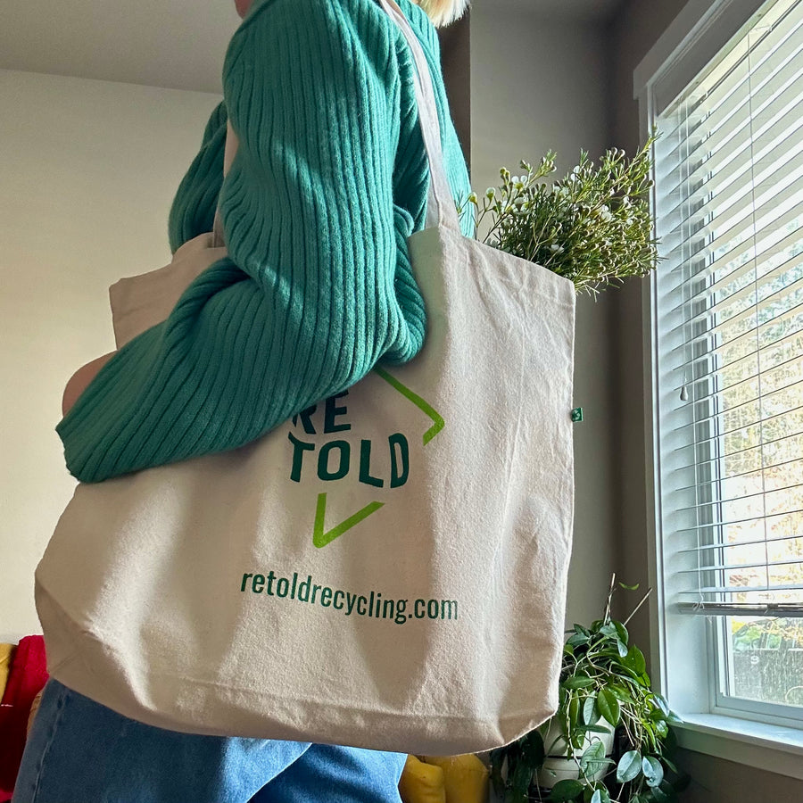 Person in green sweater modeling Retold tote.